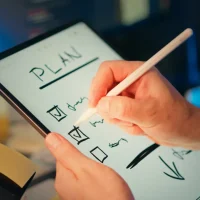 hand writing a plan checklist on a tablet